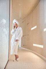 Fototapeta premium Woman with a gadget standing in the corridor