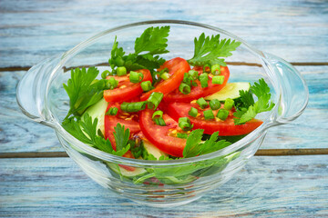 Salad of tomatoes and cucumbers on blue wooden table. Selective focus