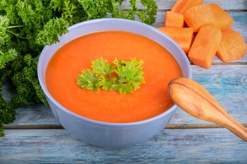 Creamy vegan carrot soup with fresh herbs. Vegetarian food