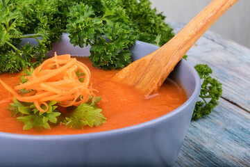 Creamy vegan carrot soup with fresh herbs. Healthy food. Close up