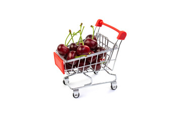 Cherry berries in a small trolley on a white background. Trading concept.