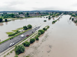 Cars and people cannot cross a flooded road. Aerial view of the flooded road, streets and houses in the city. Global catastrophe, climate change, flood concept