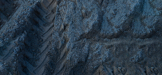grey sand shot from above with tire marks