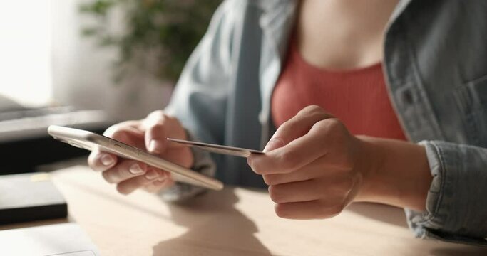 Female hand holding credit card and shopping online. Easy pay using digital gadget. Girl using laptop at home. Happy woman with compact computer and bank card shopping online. Lifestyle.