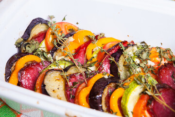 Grilled vegetables with salami in a white dish