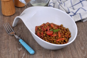 Petits pois cuisinés avec de la sauce tomate et des lardons