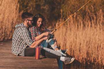Couple fishing on lake docks