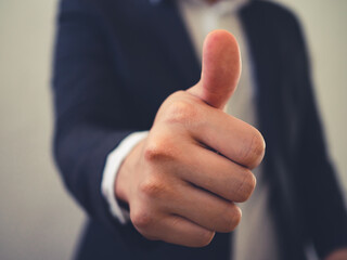 Close up of business man showing thumb up in concept approval or good business.