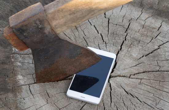 modern cell phone and a rusty axe. Selective focus. The concept of refusing to use gadgets