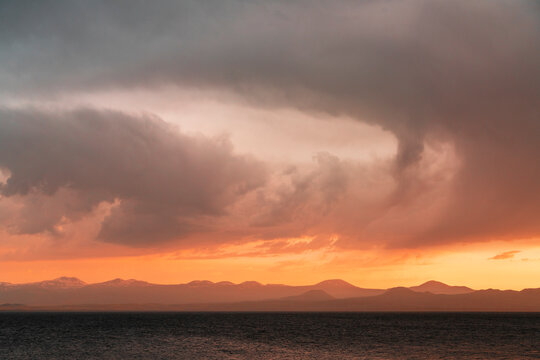 Beautiful landscape. Bright golden sunset with dramatics clouds over the lake after rain.