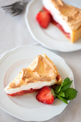 Slice of delicious strawberry tart with meringue on wooden background. Summer food