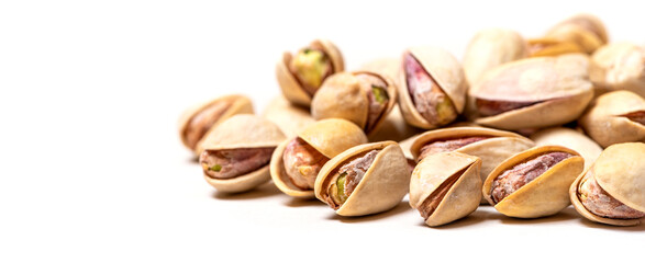 Pile of salted pistachios on a white background closeup selective focus. Pistachios background, free space for text.