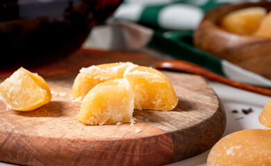 Slices of pressed palm sugar on a wooden cutting board. Close-up of palm sugar on a served table.