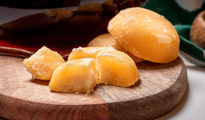 Slices of pressed palm sugar on a wooden cutting board. Close-up of palm sugar on a served table.