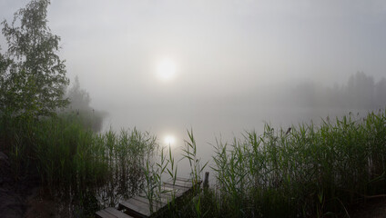 Fog over the lake in the early summer morning.