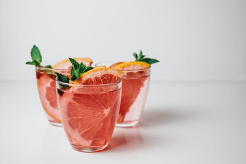 Pink drink, cocktail with grapefruit slice and fresh mint on a white background. Copy space