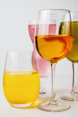Glasses with multi-colored drinks on a white background.