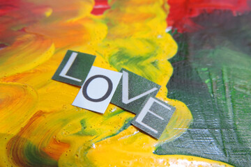     letters cut from magazines and the word love is made up on abstract stains of yellow-green...