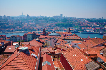 Fototapeta na wymiar Roofs and in the background the Douro river in Porto, Portugal