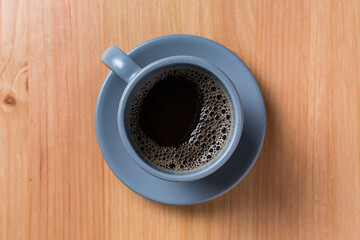 Coffee in a grey cup on a wood table on top view with space for copy text