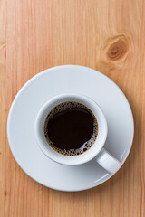 Coffee in a white cup on a wood table on top view with space for copy text