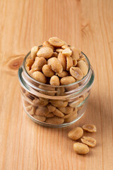 Peanuts in a small glass on a wooden table
