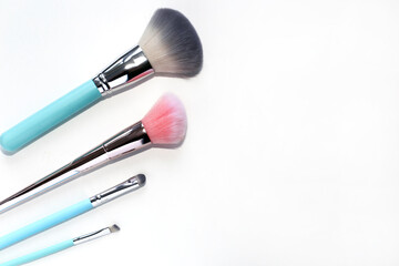 Pink and blue makeup brushes on a white background
