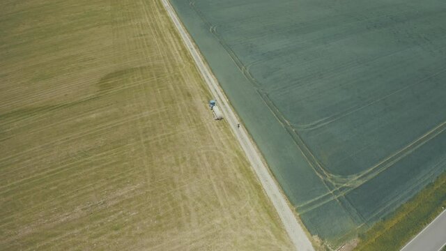 Aerial view of farming tractor. Natural eko fertilizer with manure.  Trailer fertilizes a freshly plowed agriculural.
