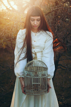Beautiful young woman with bird cage