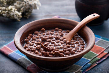 Chocolate cereal balls with milk in a bowl. Tasty breakfast