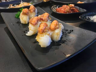 Sushi Set nigiri and sushi rolls with tea served on gray stone slate on metal background in japan