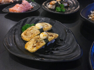 Sushi Set nigiri and sushi rolls with tea served on gray stone slate on metal background in japan