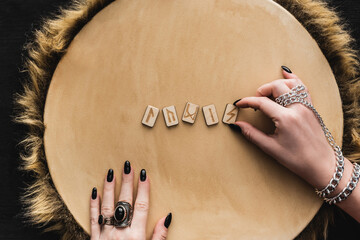 Top view of woman touching ancient runes on wooden surface