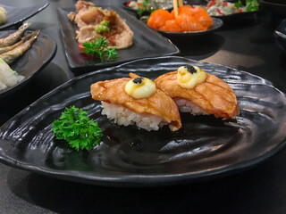 Sushi Set nigiri and sushi rolls with tea served on gray stone slate on metal background in japan