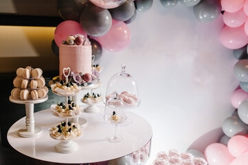 Delicious wedding reception. Birthday Cake on a background balloons party decor. Copy space. Celebration concept. Trendy Cake. Candy bar. Table with sweets, candies, dessert.