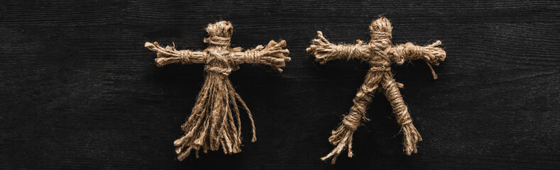 Panoramic shot of creepy voodoo dolls on black