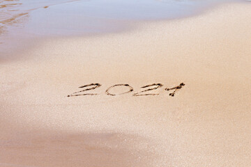 2021 text on the beach. Planning vacation.