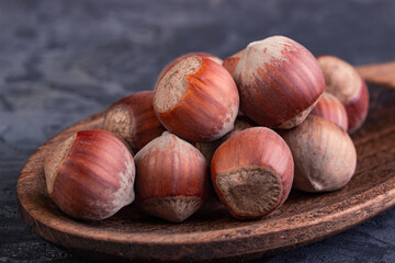 Hazelnuts in a spoon on a dark background