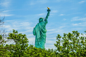 The back of the outdoor Statue of Liberty  designed by Alexandre Gustave Eiffel on a blue sky...