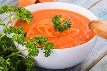 Creamy vegan carrot soup with fresh herbs. Healthy food. Close up