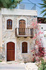 Fototapeta na wymiar Facade of house in Greek style. Entrance to house in one of villages of Crete. Traditional style.