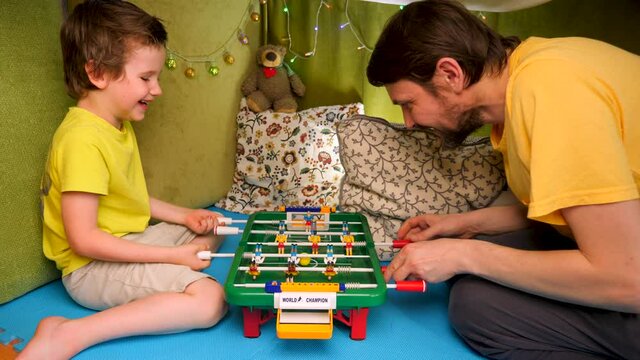 Playing table football. Happy childhood concept. One parent family. Enjoying time with child. Spending time with family. Stay at home