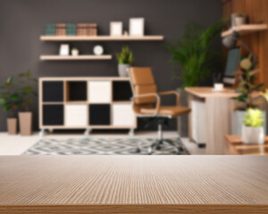 Empty wooden surface and blurred view of modern office interior, closeup. Space for text