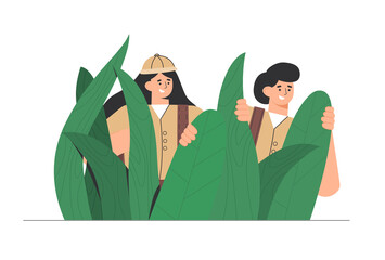 Explorers, travelers in the jungle large green leaves. Man and woman enjoy a picturesque landscape of plants. Concept of discovery, exploration, hiking, adventure tourism and travel.