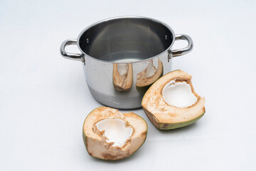 young coconut meat in glass bowl, with young coconut water in stainless bowl