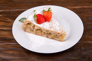 Charlotte with apples, sprinkled with powdered sugar with mint