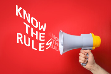 Man using megaphone to say Know the rules on red background, closeup