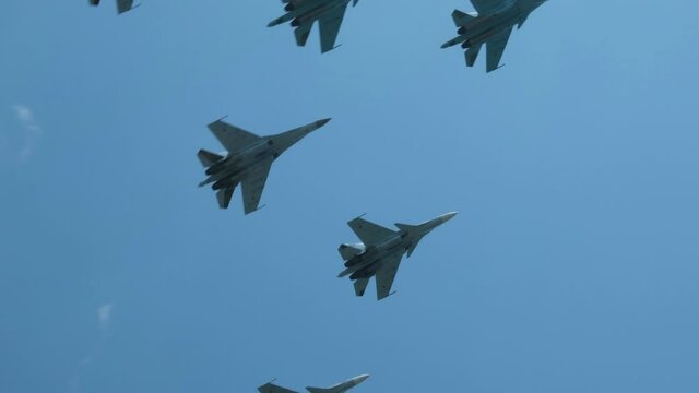 Column military warplanes flies over the ground in honor of the victory parade . Military planes in a beautiful blue sky. Air force parade.