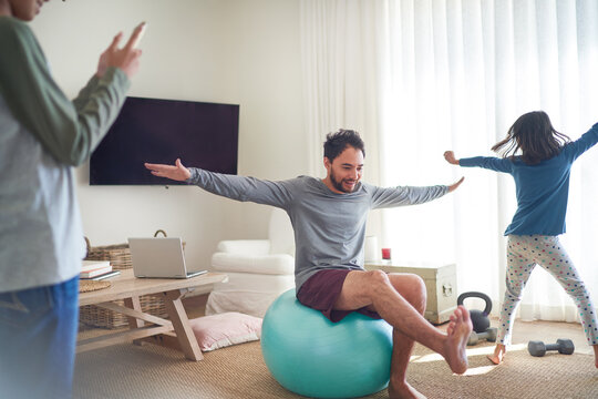 Father and kids exercising and playing in living room