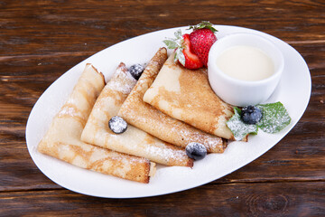 Fried pancakes with clot and fresh berries

